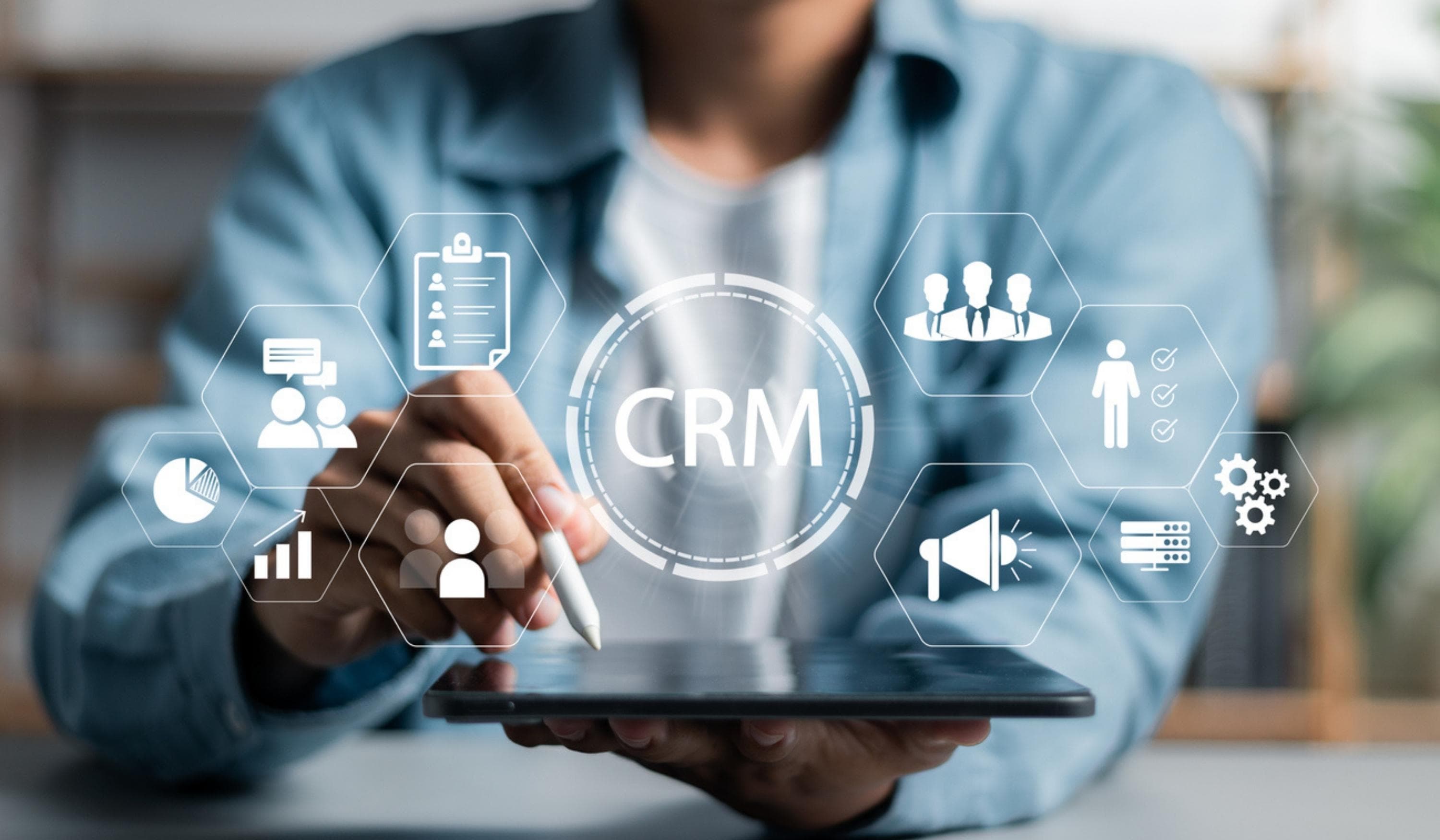 Nutzer arbeitet mit CRM-Dashboard auf einem Tablet mit digitalen Icons