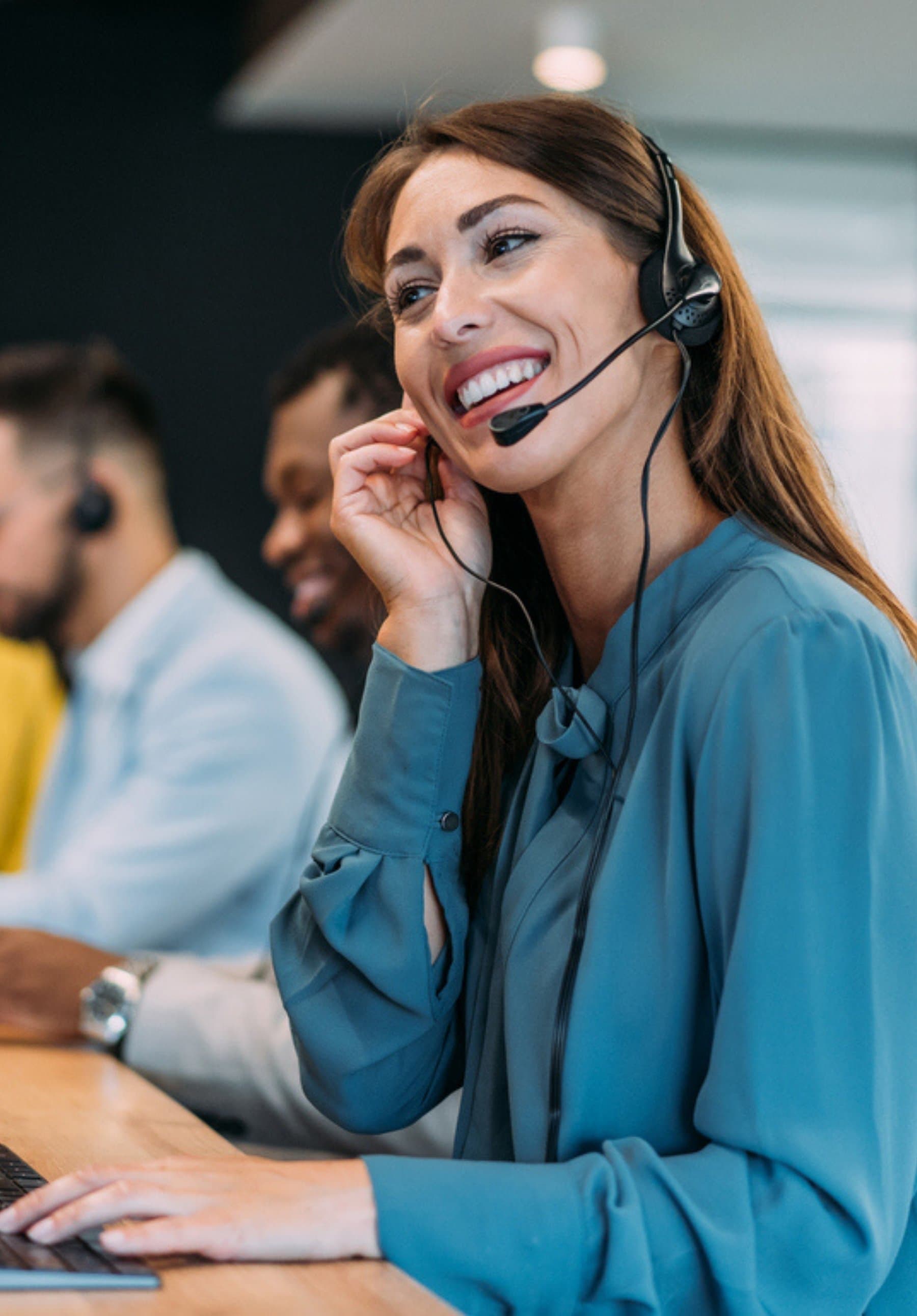 Lächelnde Kundenberaterin mit Headset im modernen Service-Team – Symbol für empathischen, lösungsorientierten Kundensupport im digitalen Zeitalter.